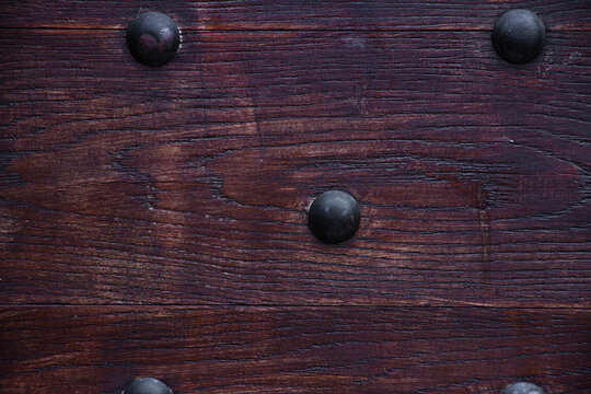 Dark brown aged wooden planks with metal studs texture