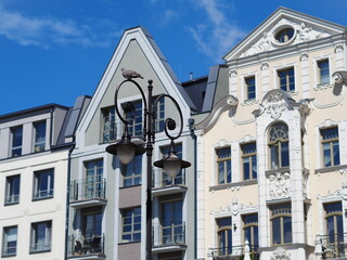 Obraz premium A double street lamp against a background of bright houses