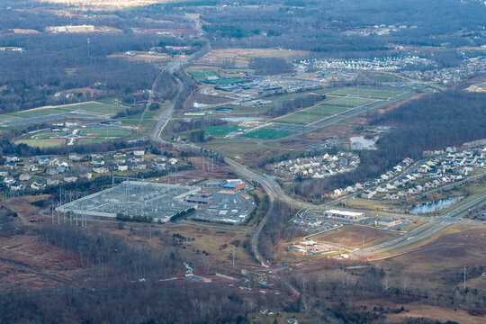 Aerial view of Northern Virginia showing high school athletic complex with baseball diamonds and football field, and an electrical substation serving the Dulles data center corridor.