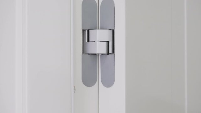 Concealed door hinge mechanism providing minimalist interior design