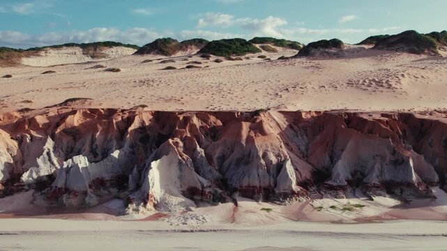 Drone lateral shot of colorful sandstone cliffs in Morro Branco Cear&aacute; Brazil