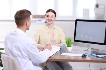 Obraz premium Medical assistant helping patient at desk in clinic, selective focus