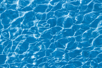 Obraz premium Abstract blue swimming pool water surface with sunlight reflections and ripple pattern background