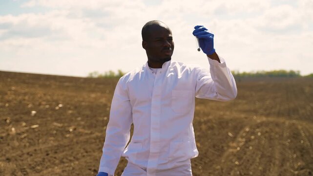 African American agronomist checking soil sample in field
