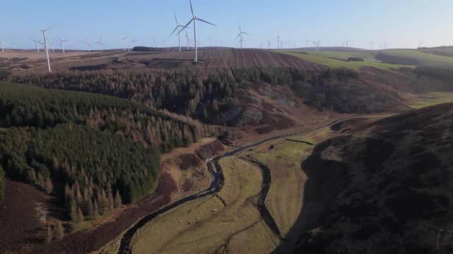 Aerial view of Crystal Rig Wind Farm with turbines on rolling hills and a valley near Dunbar, Scotland, United Kingdom.
