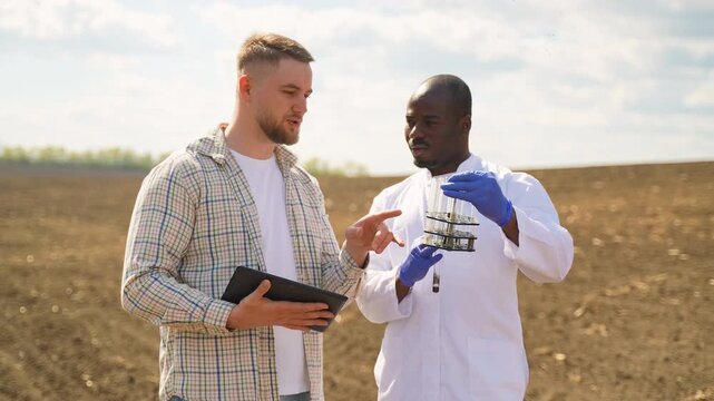Farmer and agronomist analyzing soil samples in the field