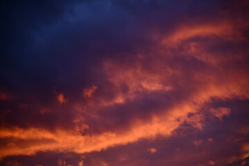 Fototapeta premium Remote view of helicopter silhouette on background of vivid sundown sky over city in evening