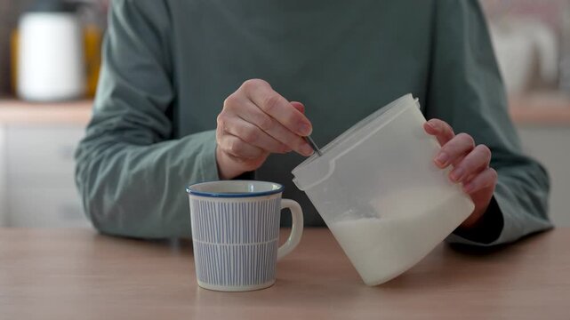 Woman using a spoon adding too much sugar to drink tea or coffee in cup, closeup. Addiction, unhealthy nutrition, diet concerns and diabetes problems, insulin spike
