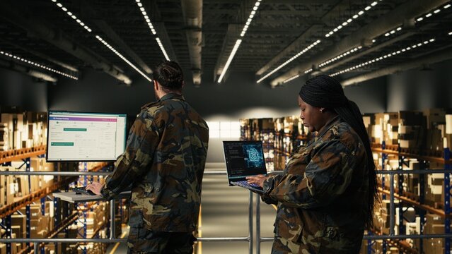 Military officer using AI-powered tools in warehouse at military base, monitoring artificial intelligence software on laptop, Machine learning and neural networks supporting tactical operations.