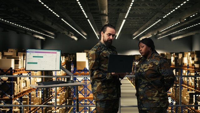 Armed forces diverse personnel working in military warehouse and managing cargo for defense, inspection for inventory, Soldiers ensuring command and control systems in military base.