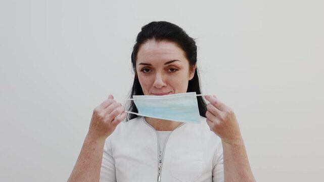 A female doctor puts a mask on her face