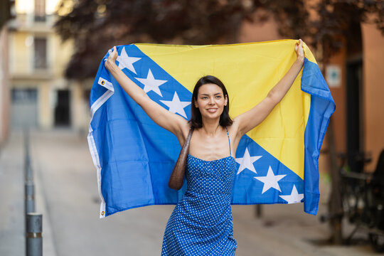 Young woman in summer dress with Bosnia and Herzegovina flag on city street