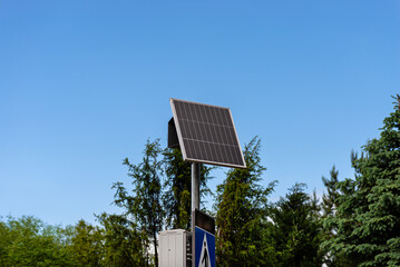 Obraz premium Solar panel powering pedestrian crossing sign on pole