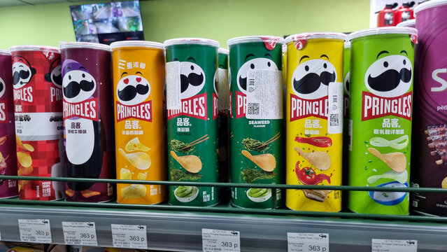 Imported Pringles Potato Chips on Supermarket Shelf, Snack Food Retail Display Editorial
