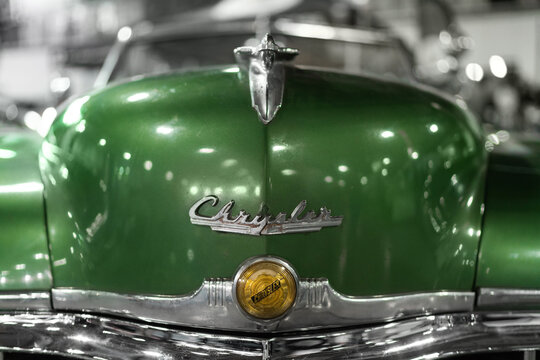 Milan, Italy - 12.11.2022: Classic green Chrysler car front with chrome details in vintage setting. Milano Autoclassica exhibition.