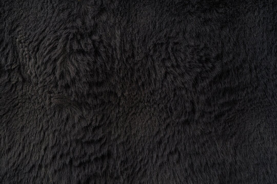 Dark black faux fur texture with soft vertical fibers and elegant plush surface, premium luxury background for Black Friday sale banners, fashion branding and cosmetic product display