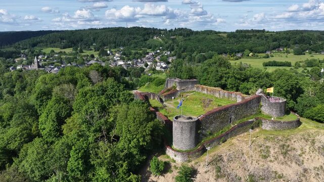 Vue a&eacute;rienne panoramique des ruines m&eacute;di&eacute;vales du ch&acirc;teau de Herbeumont en Belgique, dans la province du Luxembourg en Wallonie. Au fond le village les champs et les for&ecirc;ts au mois de juin 2026