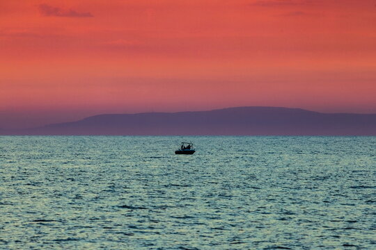 Barca con pescatori al tramonto con mare calmo