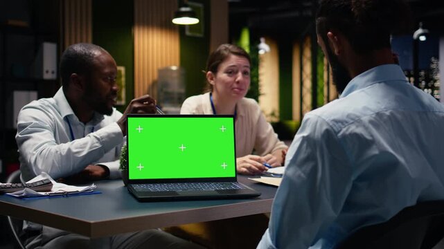 Mockup chroma key laptop used by office employees doing business meeting to plan project and devise strategy. Businesspeople doing research analysis with data, using notebook.