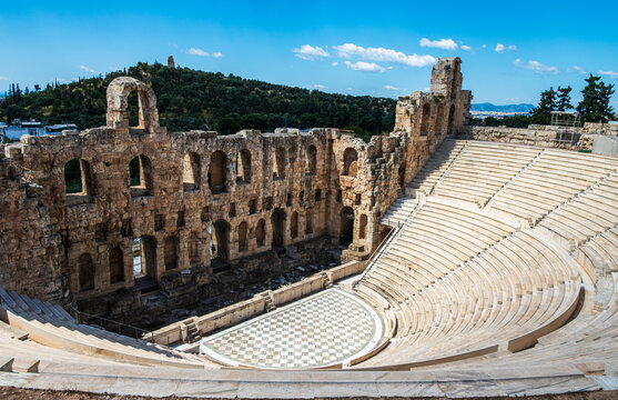 View of the Odeon of Herodes Atticus on the slopes of the Acropolis in Athens, with Philopappos Hill rising in the background