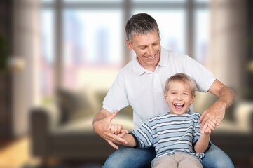Obraz premium Cheerful father and son at home, have fun together
