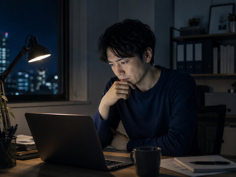 夜遅くまでパソコンに向かう男性｜残業・仕事の悩みを表現したイメージ