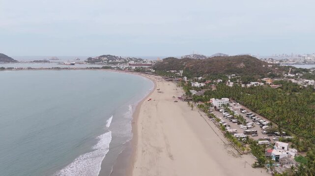 Video a&eacute;reo capturado con dron sobre la Playa Isla de la Piedra en Mazatl&aacute;n, Sinaloa, M&eacute;xico. La toma muestra una extensa playa de arena junto a aguas tranquilas del oc&eacute;ano Pac&iacute;fico.