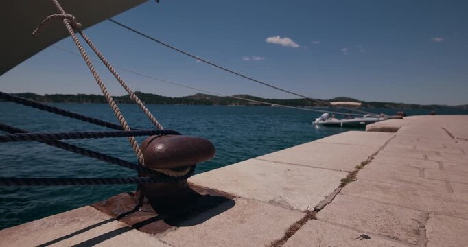 Close up view of a mooring bollard with ropes on a waterfront promenade in Sibenik, Croatia.
