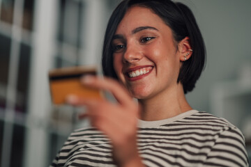 Young woman smiling, holding credit card for online shopping, consumerism, and digital payment © Zamrznuti tonovi