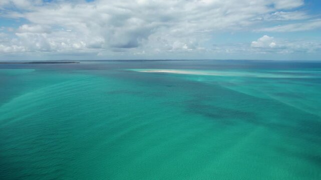 Aerial view of the turquoise waters and sandbar of Pelican Bank under a cloudy sky K'gari, Hervey Bay, Queensland, Australia.