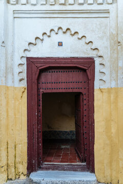 Open wooden door in old design arch