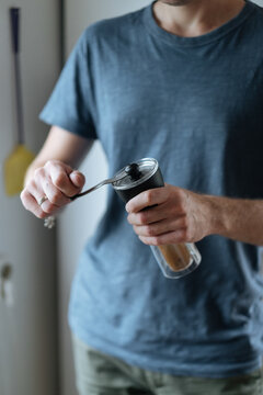 Crop man grinding coffee