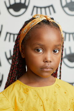 Little Girl In Yellow Dress Looking At Camera