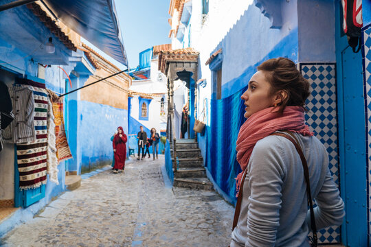 Woman excited looking along colorful house in city