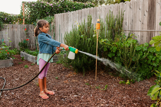 Girl Watering Garden Hose Backyard