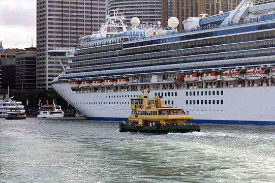 The Manly Ferry sails past a cruise ship moored at Circular Quay, Sydney, Australia