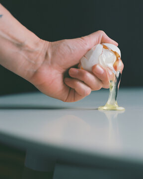 A hand squeezes an agg, an emotional hand movement