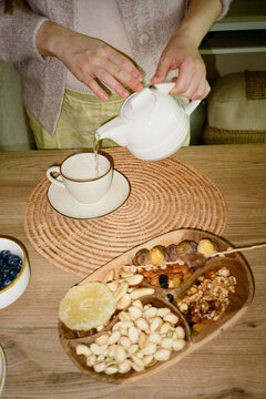 Pregnant woman pouring tea into a cup