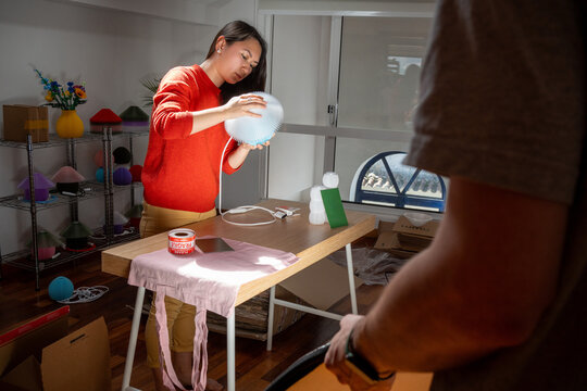 Woman Crafts With Materials at Table in Bright Workshop Space
