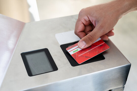 Unrecognizable man swipes public transportation card through reader