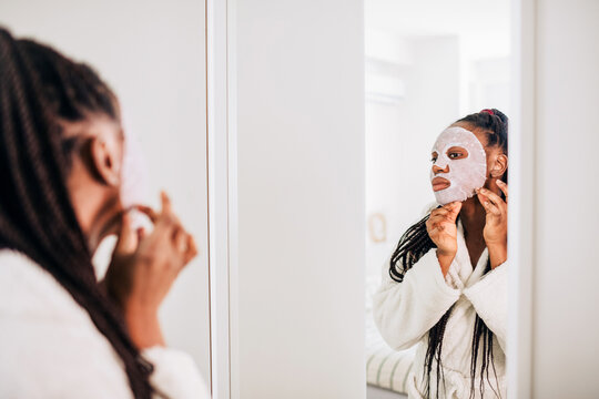 Home portrait of a happy african american woman with face mask 