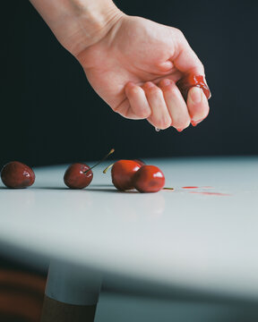 Squeezing cherry in hand. 