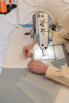The guy sews clothes in the creative space.