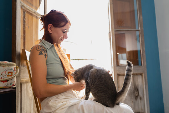 Woman Enjoying a Cozy Moment With Her Cat Indoors