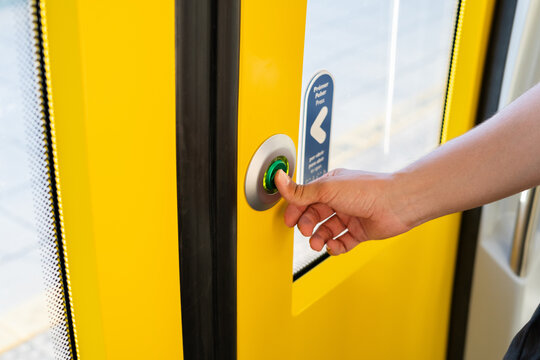 Passenger pushing button to open door on public transport