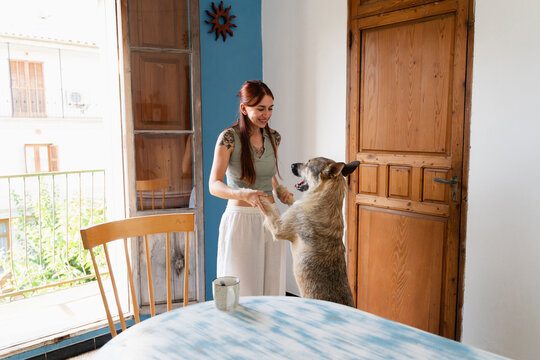 A happy woman dancing with her dog in a cozy atmosphere