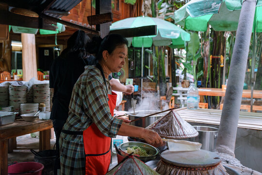 Woman cooking a Thai traditional dish Mee Phan