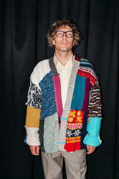 Man stands with a unique patchwork sweater