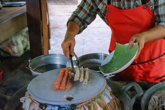 Woman cooking a Thai traditional dish Mee Phan
