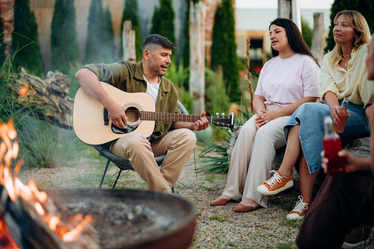 Friends are sitting around a campfire